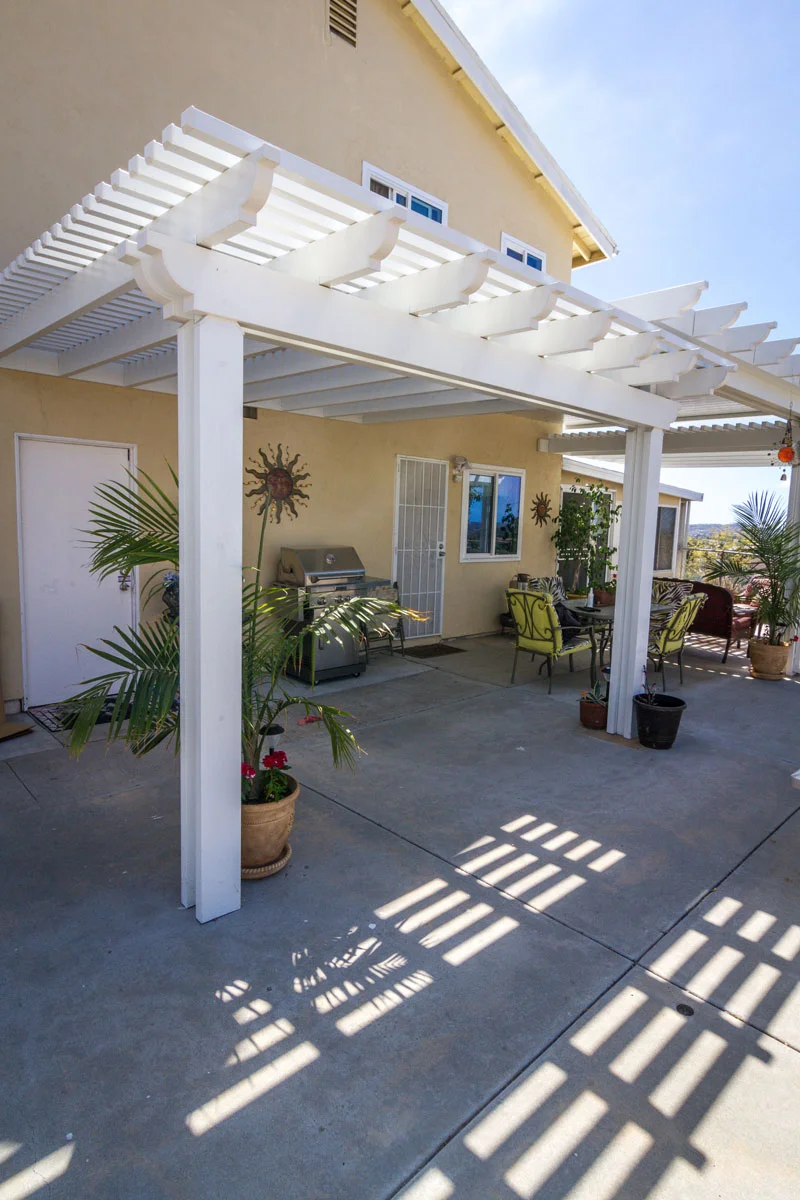 White alumawood patio cover with adjustable louver panels over concrete patio