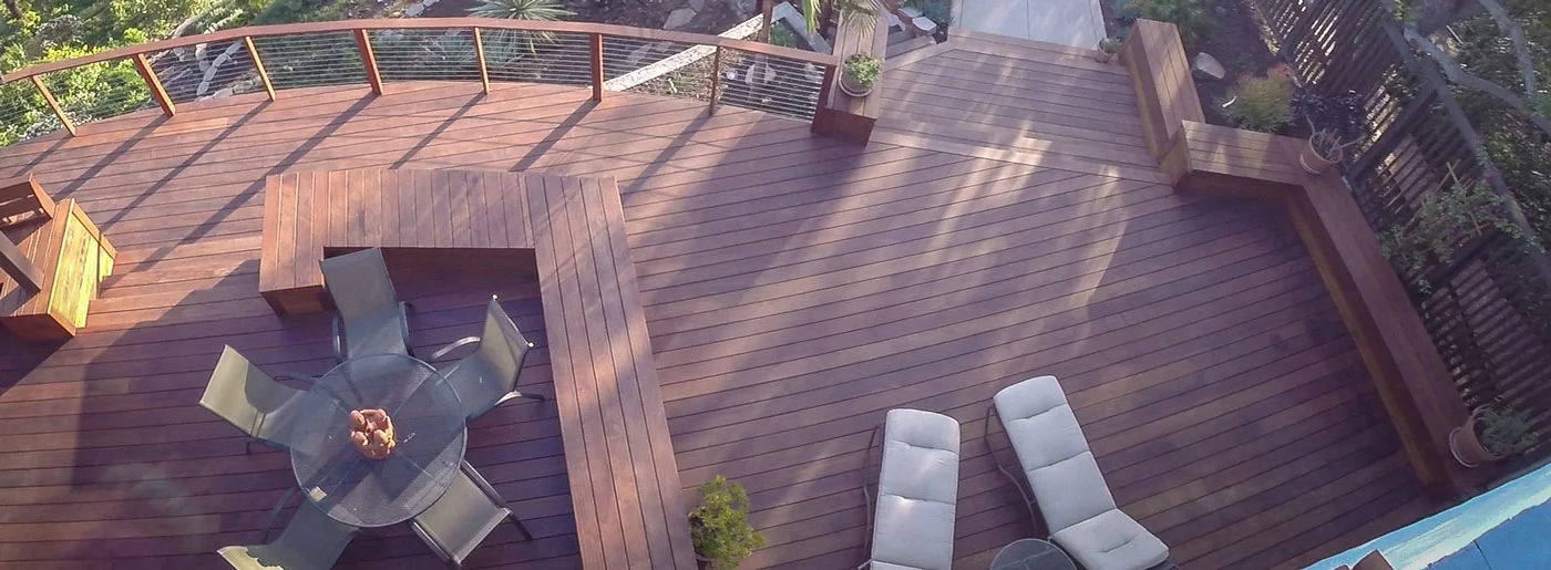Aerial view of multi-level composite deck with curved design, cable railings, and built-in seating
