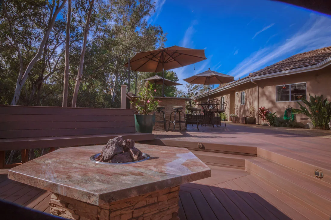 Composite deck with stone fire pit, built-in benches, and multi-level design